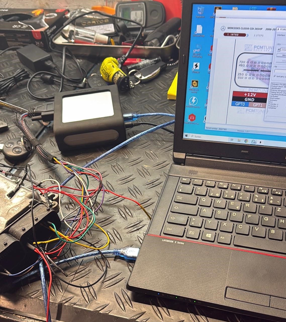 Laptop mit Steuergeräte-Software und angeschlossenem Fahrzeugmodul